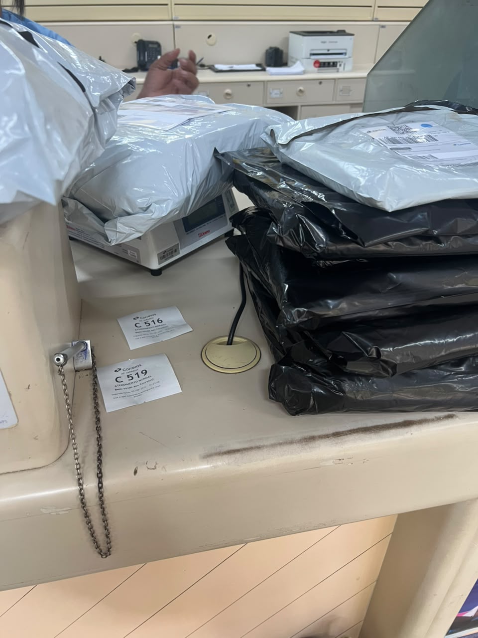 Pedidos sendo pesados e postados no balcão dos Correios